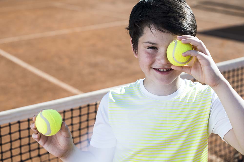 kid-covering-his-eye-with-tennis-ball.jpg