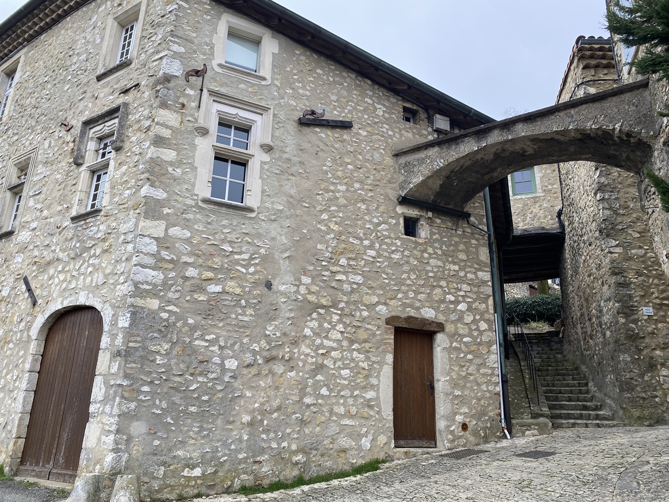 Fenêtes sculptées, arches et passage sous maison