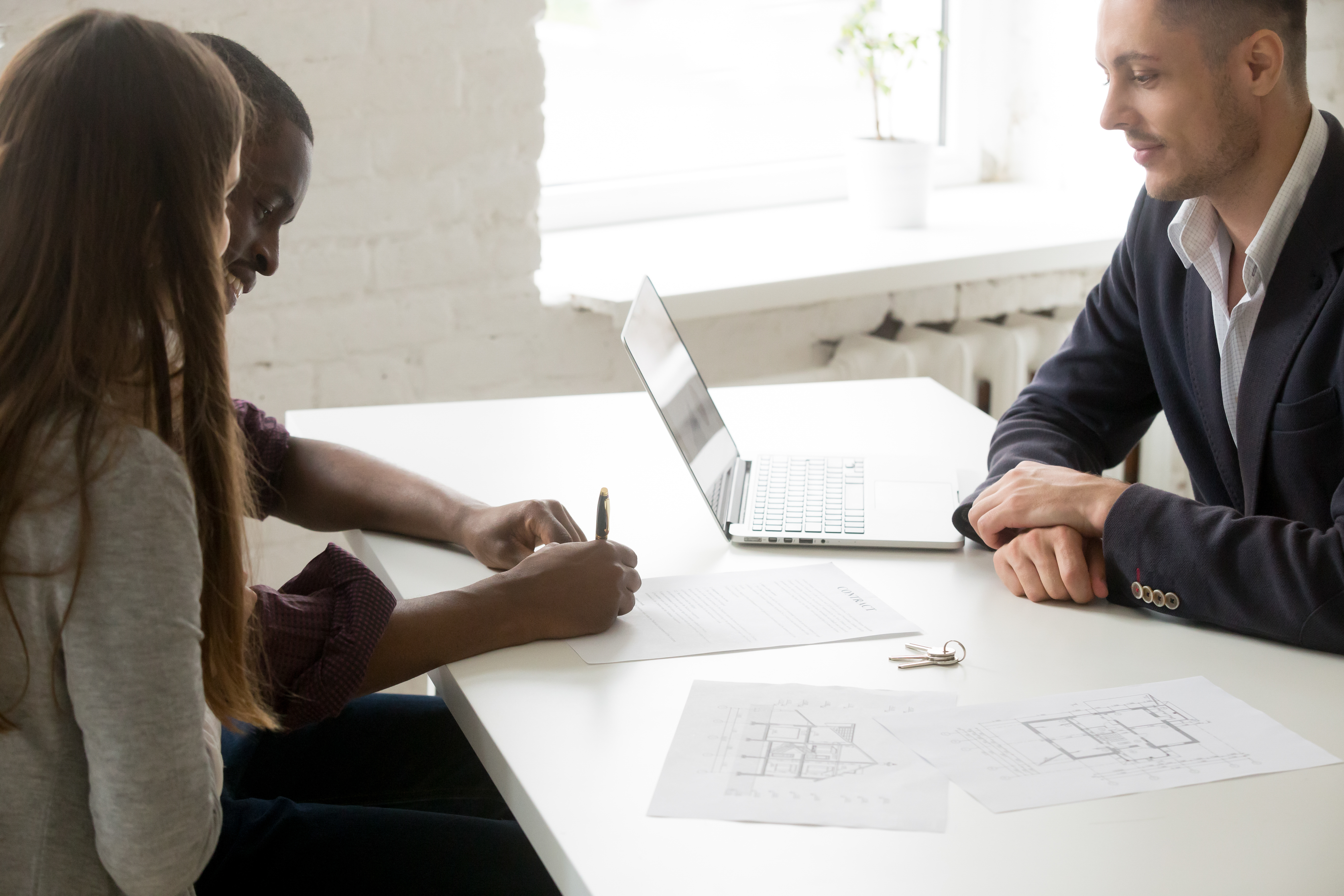 couple-interracial-signant-contrat-investissement-hypothecaire-lors-reunion-courtier.jpg