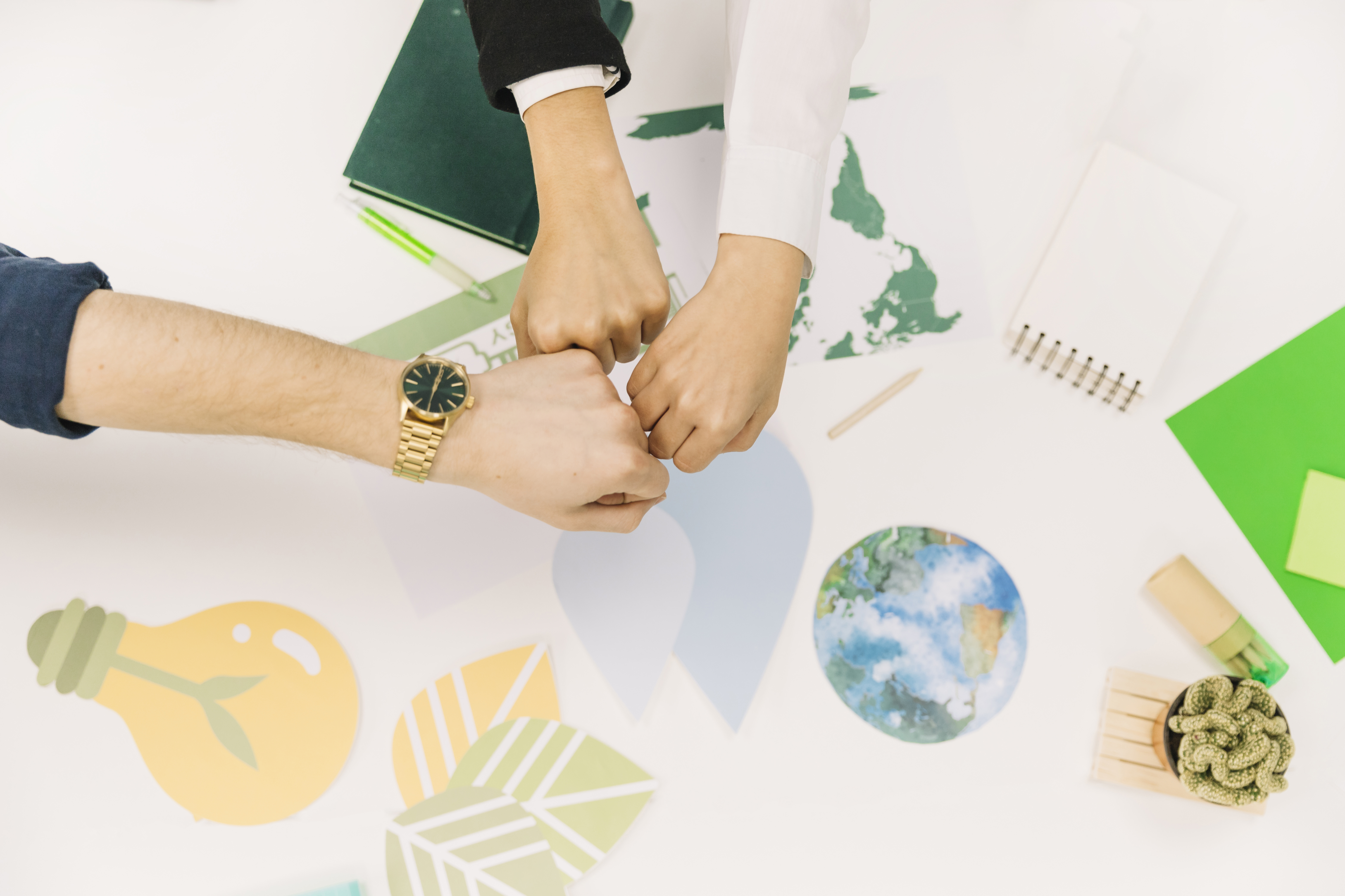 group-businesspeople-fist-bumping-desk.jpg