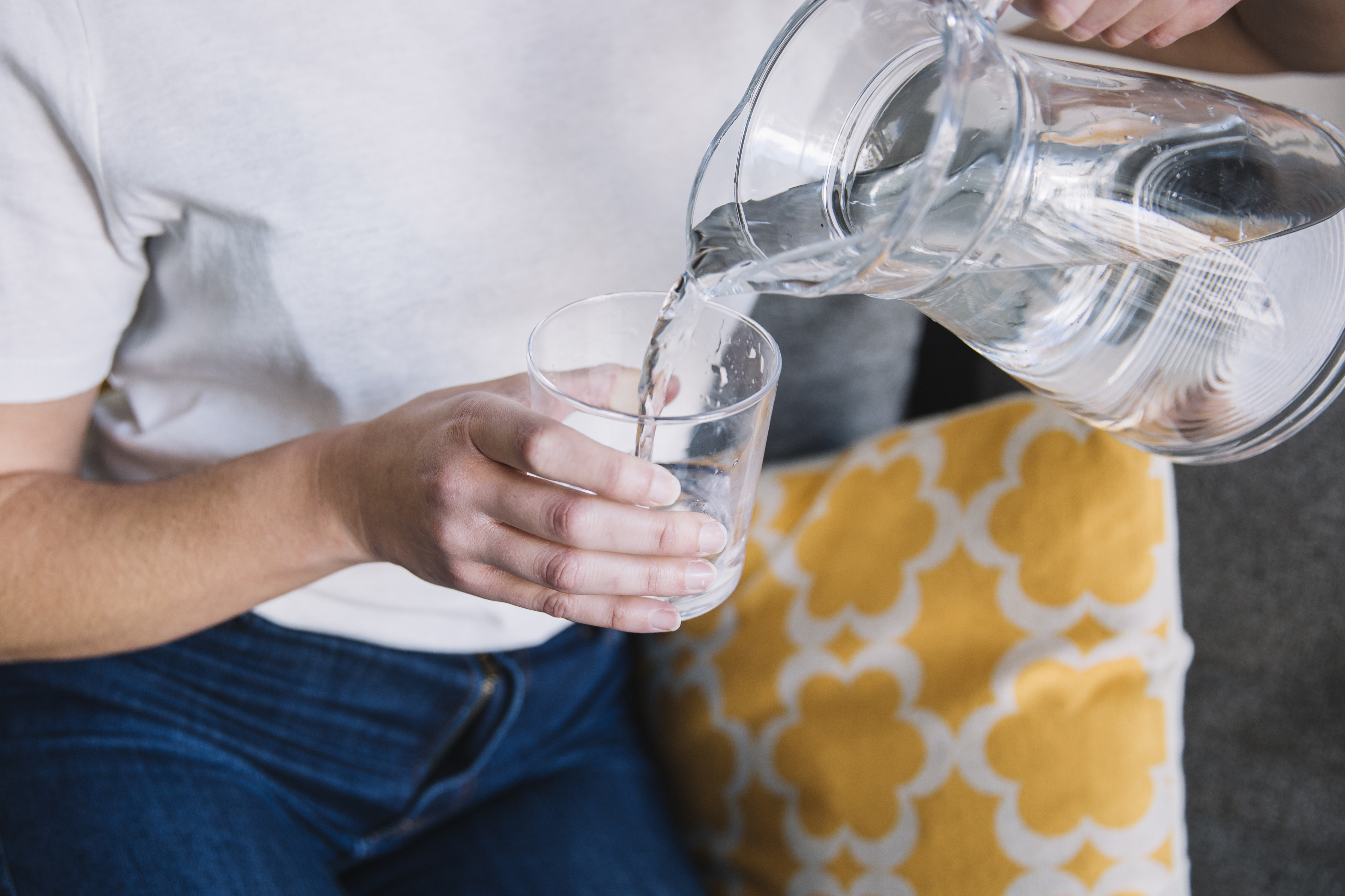 crop-woman-sofa-pouring-water.jpg