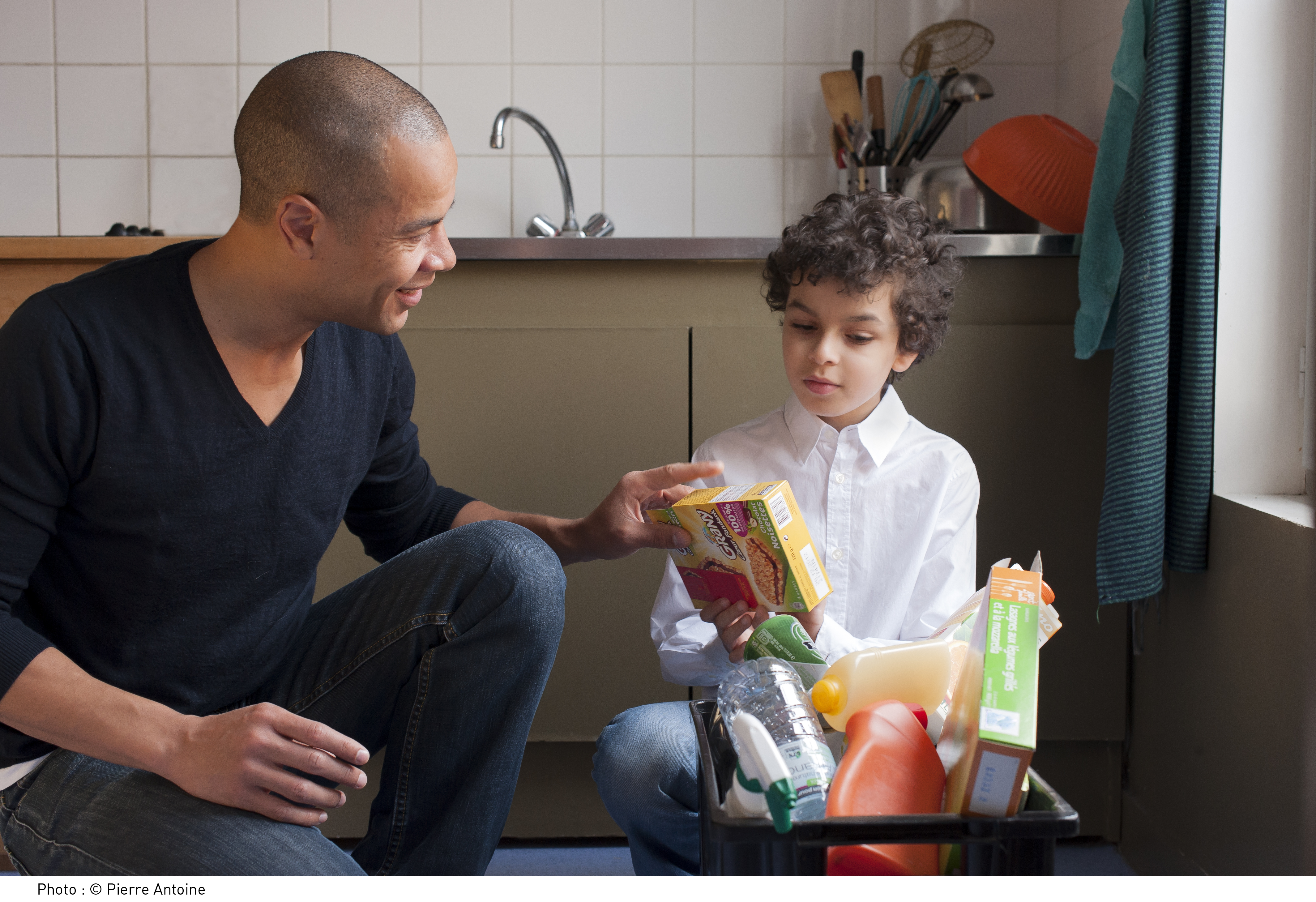 un père et son fils qui trient leurs emballages dans la cuisine.jpg